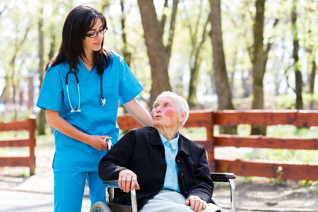 Nurse taking elderly man for a stroll